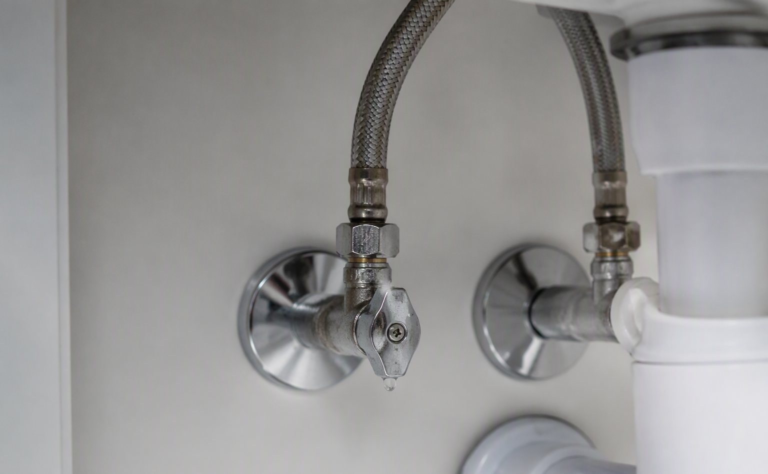 Braided steel supply lines under a bathroom sink